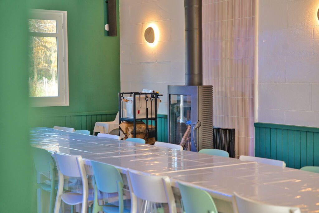 Poêle à bois dans la salle de réception du gîte Ranch de Sologne, apportant une ambiance chaleureuse lors des repas de groupe.