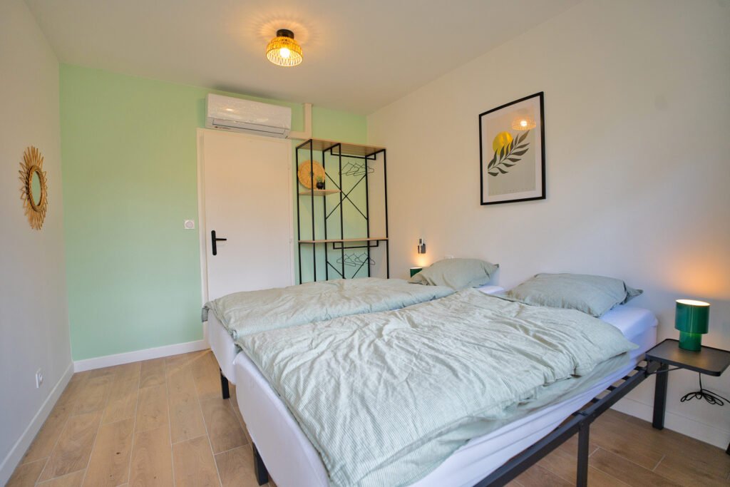 Chambre du gîte Ranch de Sologne avec lits jumeaux, climatisation et accès à la salle de bain.