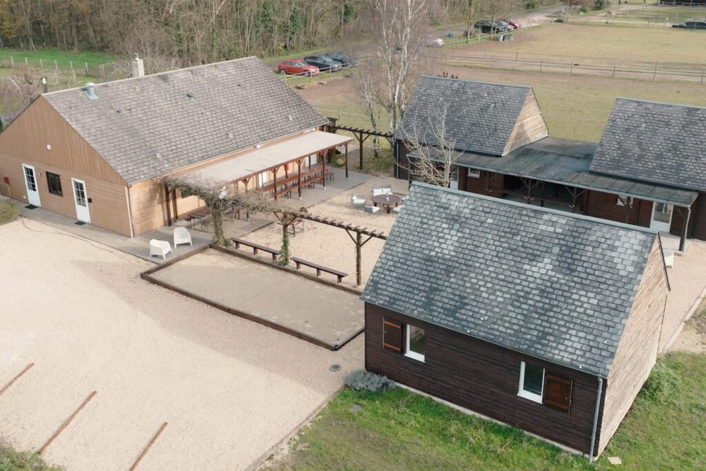 Vue aérienne du gîte Ranch de Sologne avec la salle de réception, la salle de jeux, les chambres, les dortoirs, la cour centrale et le terrain de pétanque.