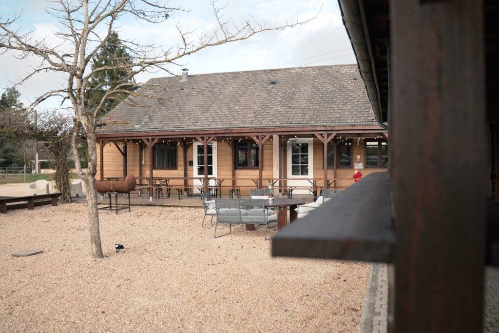 Salle de réception du gîte Ranch de Sologne avec terrasse couverte et cour en gravier.