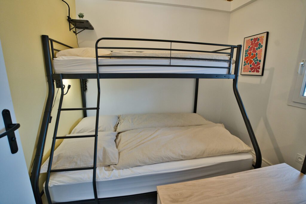 Chambre 5 du gîte Ranch de Sologne avec lit superposé double en métal noir et literie claire.